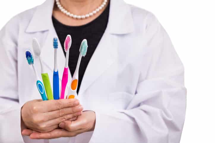 Dentist holding toothbrushes with different head and bristle design for various oral needs