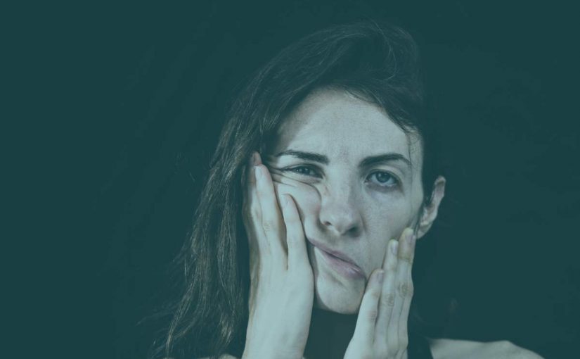 Woman holding her face in pain and frustration from the dental issue:bruxism