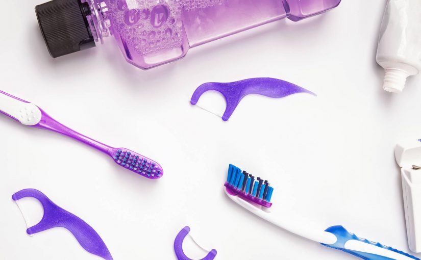 Purple dental tools - mouthwash, toothbrush, dental picks and toothpaste.