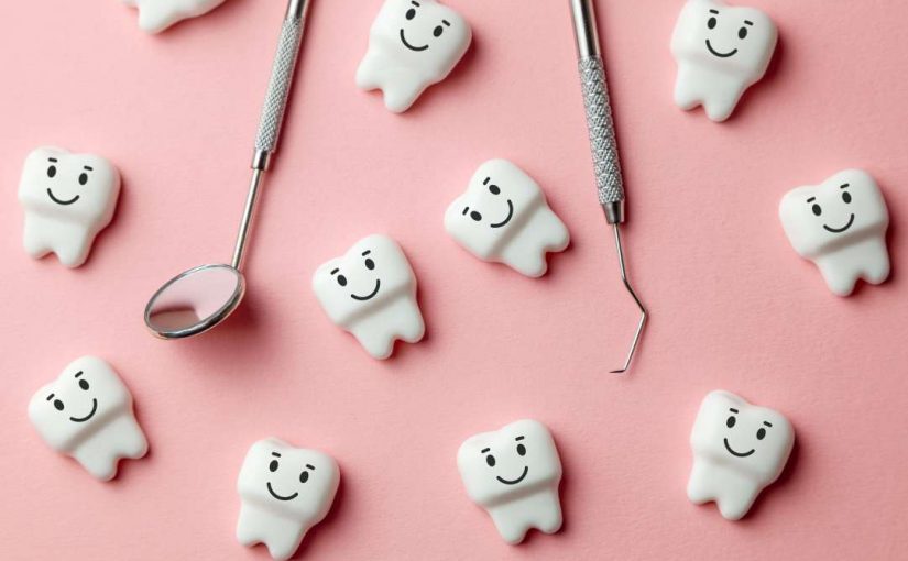 Little plastic teeth figures with smiles with a dentist's mirror and pick